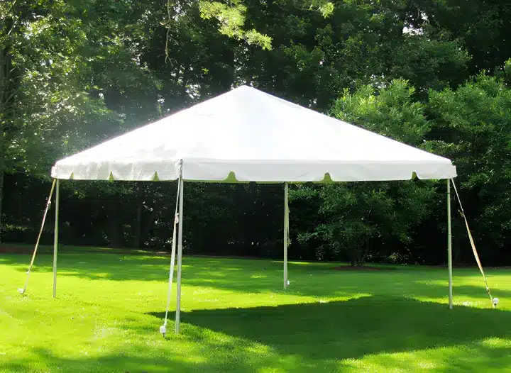A commercial frame tent anchored on a lawn. The color of the tent is white.